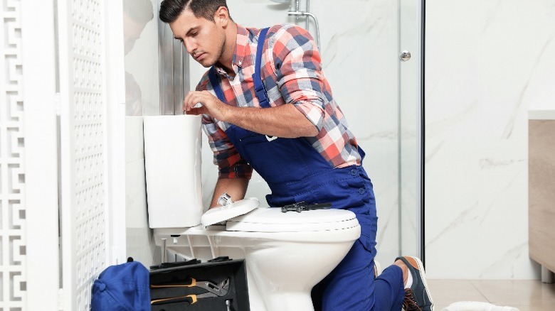 Man working on a toilet 