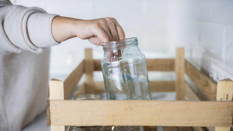 woman picking up empty jar