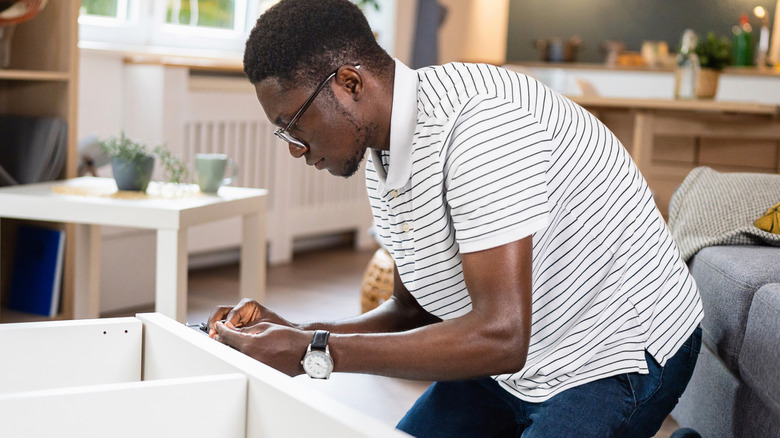 Young man assembling a nightstand