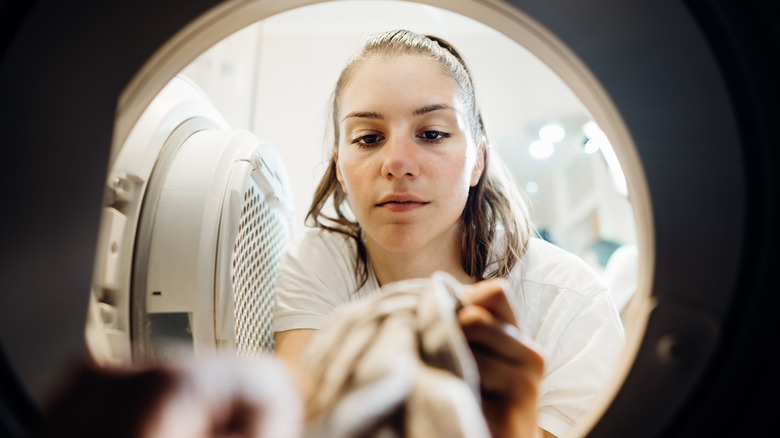 Woman peering into washing machine