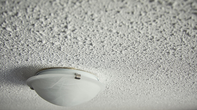 A popcorn ceiling is fitted with a lighting fixture