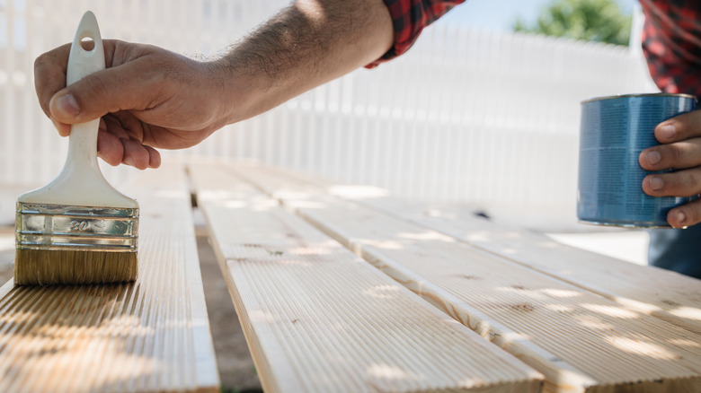 person varnishing wood