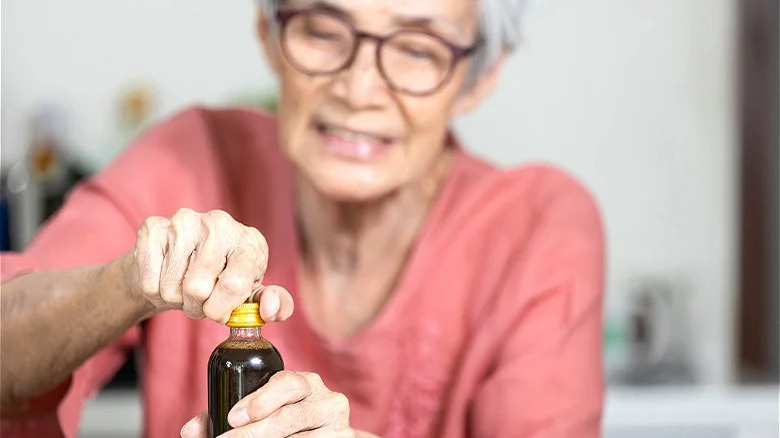 woman trying to open bottle