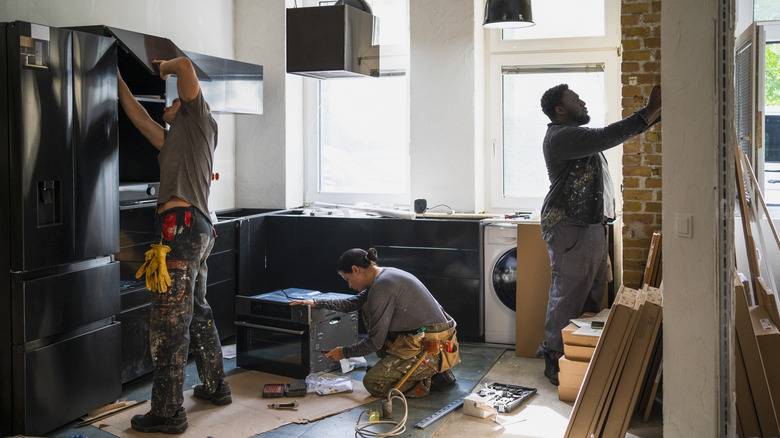 Group of people remodeling a kitchen.