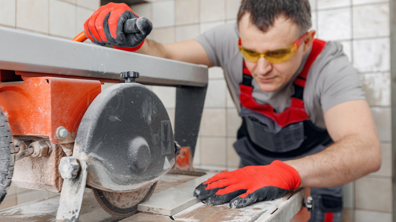 A man operating a wet cut tile saw