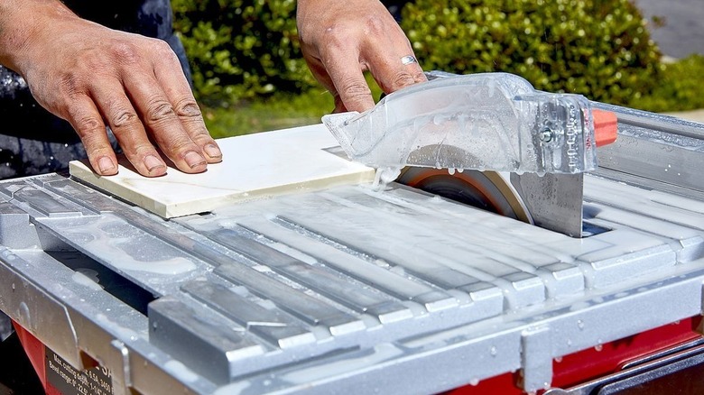 A person using a Harbor Freight 7-inch table top wet tile saw