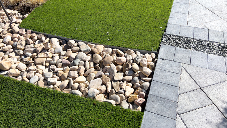 Part of a yard showing a mix of softscape and hardscape areas