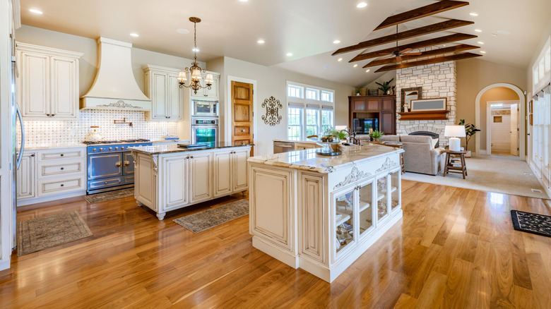 open kitchen and living room with white furniture and gleaming polished hardwood floor