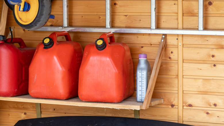 Garage corner with three red plastic fuel cans