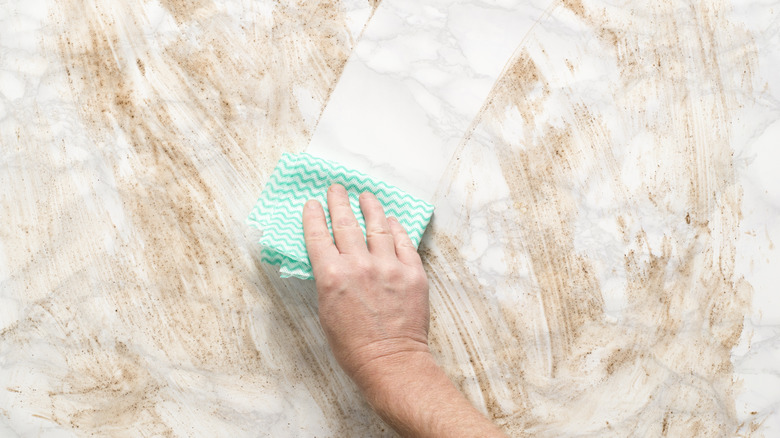 wiping dirty marble countertop