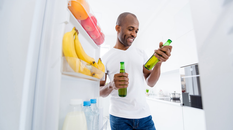 man looking at beer bottles