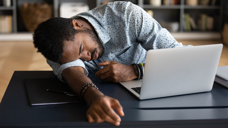 A man asleep on laptop