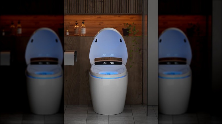 Open smart toilet in a dark bathroom