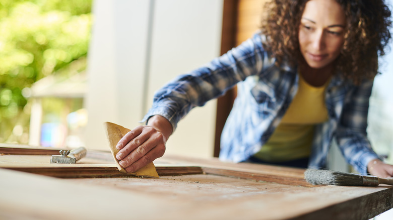 woman sanding surface