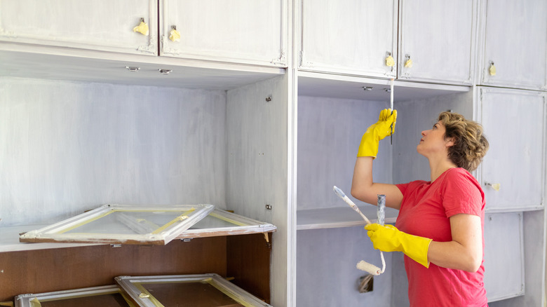 woman painting kitchen cabinets