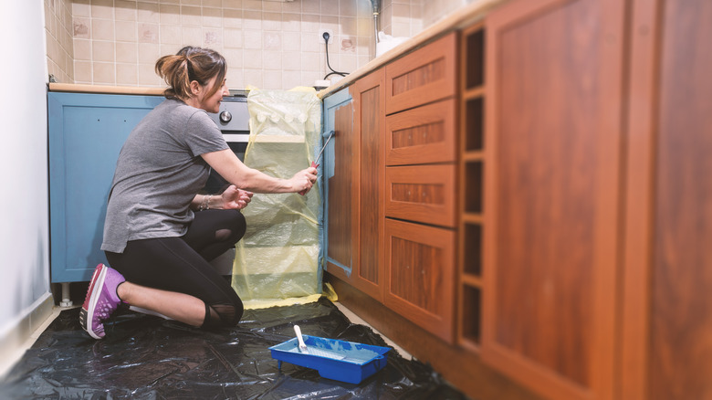 woman painting kitchen cabinets