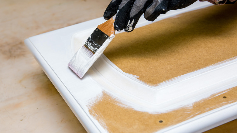 person painting cabinet doors