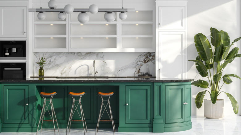 A modern kitchen with white and green cabinetry