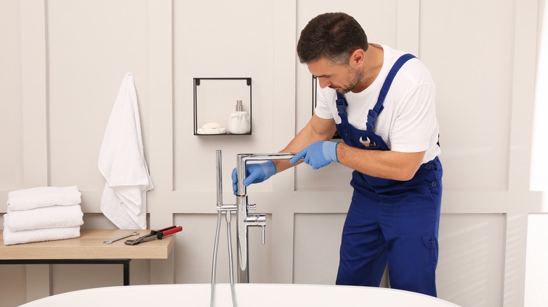 plumber installing bathtub faucet