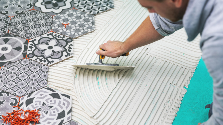 Man installing tiles to floor