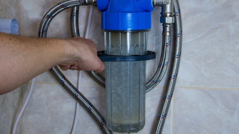 Hand adjusts small water softener