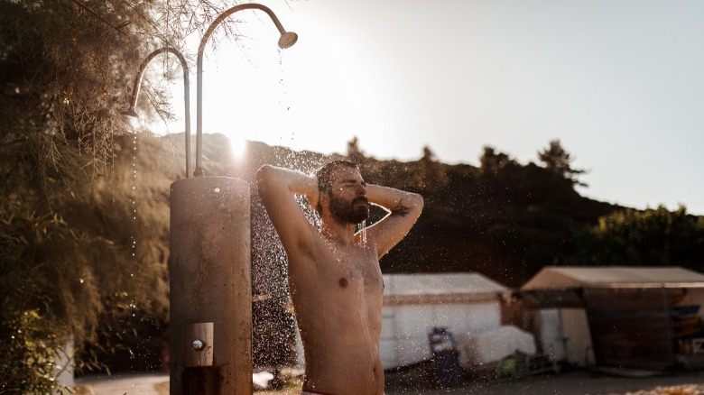 Man using outdoor shower 