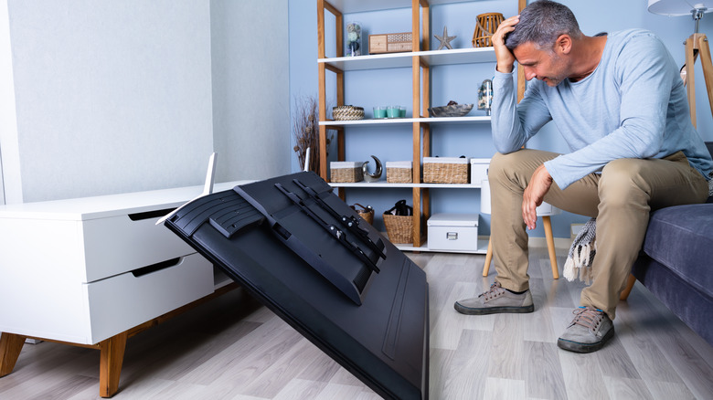 Man with fallen TV set