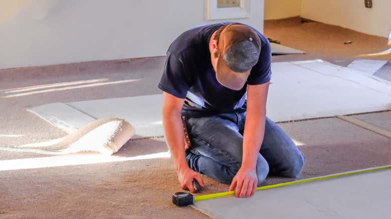 Man measuring carpet