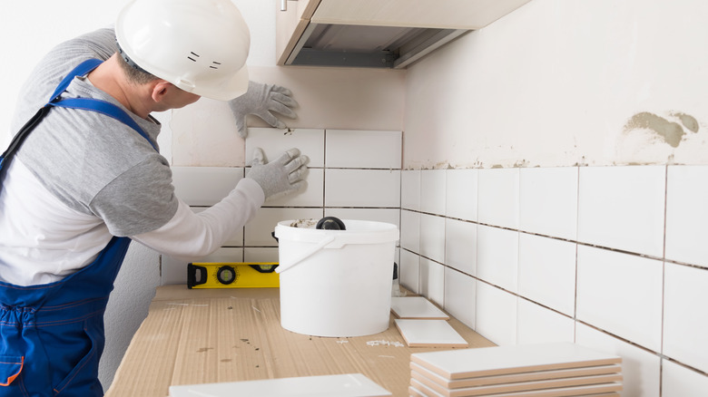 person installing floor tiles