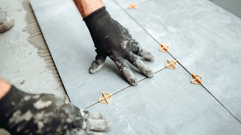 person installing tiles with spacers