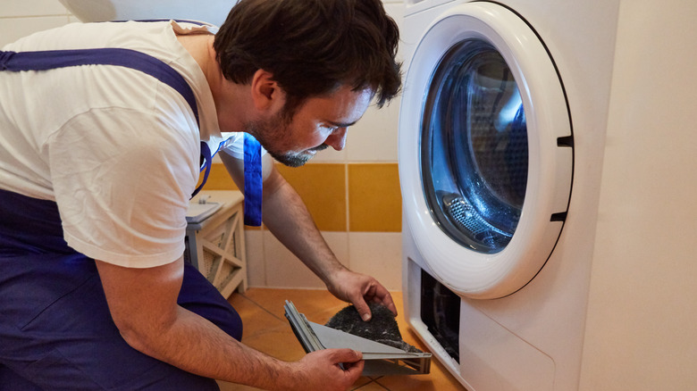 man cleaning lint trap