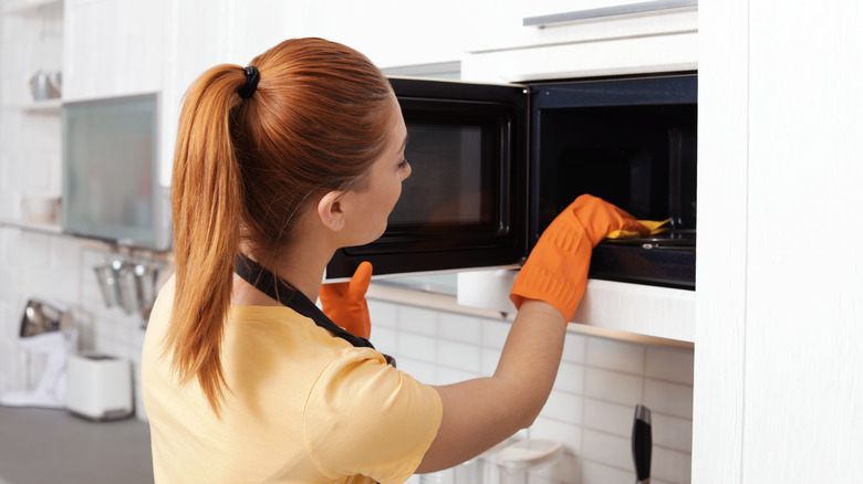 Woman cleaning microwave