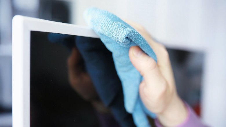 Cleaning a TV screen with a cloth