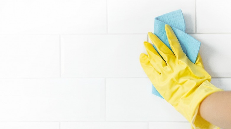 Yellow glove hand cleaning grout