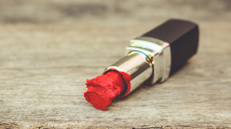 old red lipstick on a wooden table