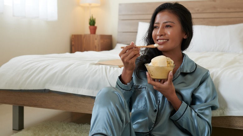 Woman eating ice cream on floor