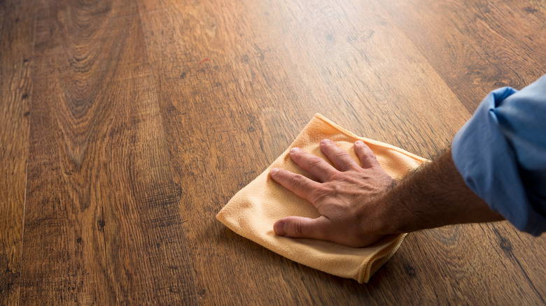 man washing waxed wooden floor