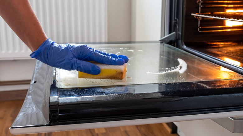 person cleaning oven