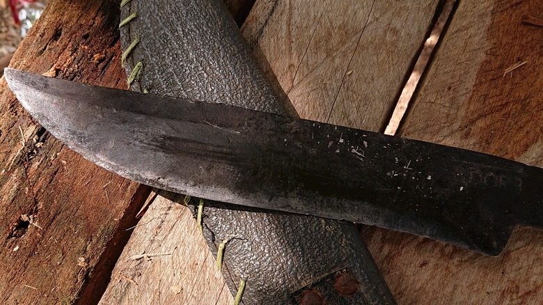 a dull machete on wooden planks