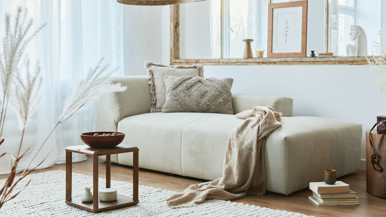 beige sofa with blanket and pillows