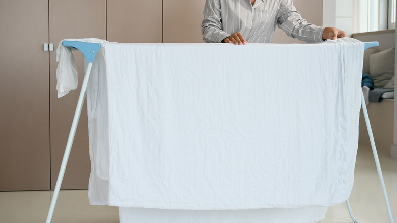 person hanging sheets on rack