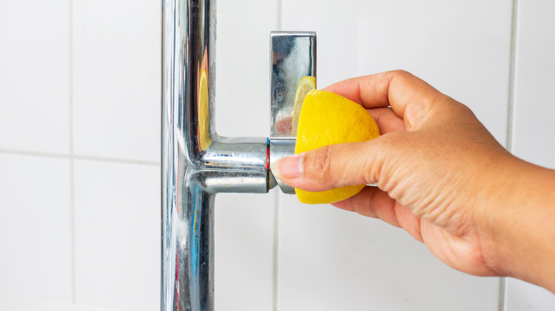 woman rubbing lemon on faucet