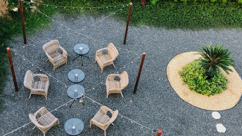 Patio furniture sitting on top of a gravel patio