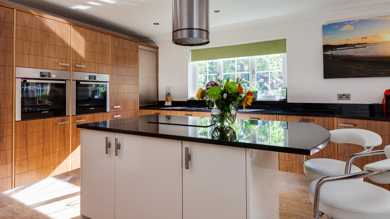 A freestanding island and kitchen cabinets pulled together by common countertops and hardware