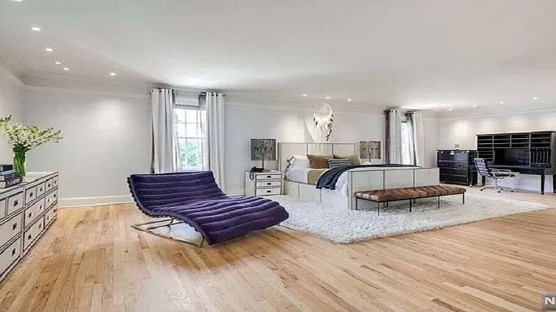 spacious bedroom with louge chair and bed in frame 