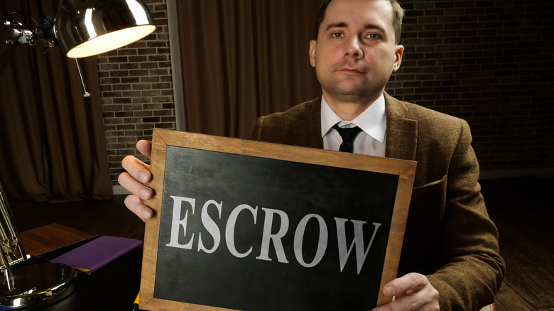 guy holding escrow sign