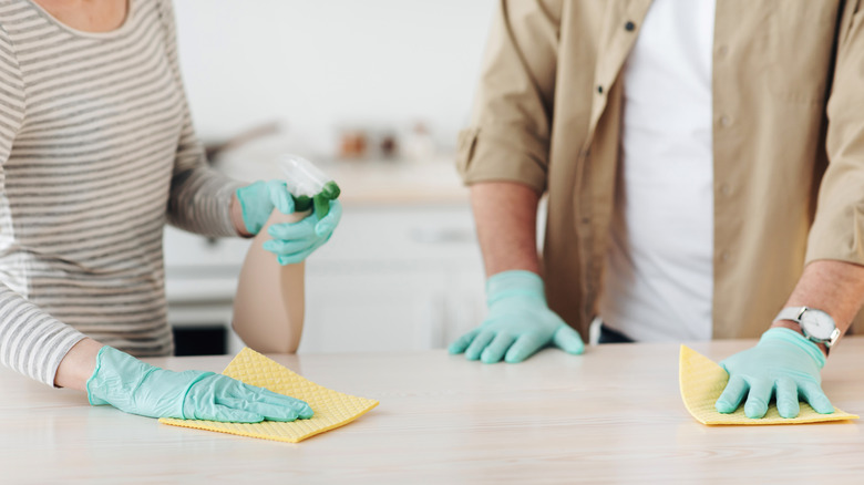 two people wiping down a counter