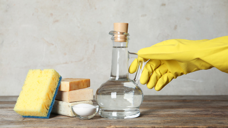 vinegar in glass bottle yellow glove