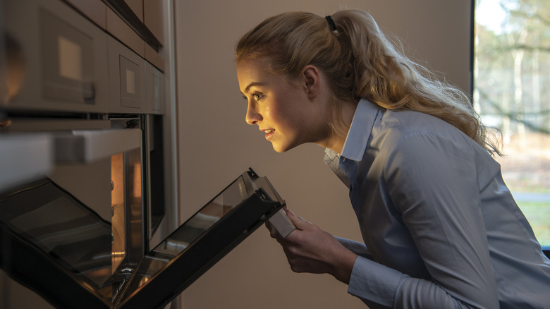 Woman looking into oven