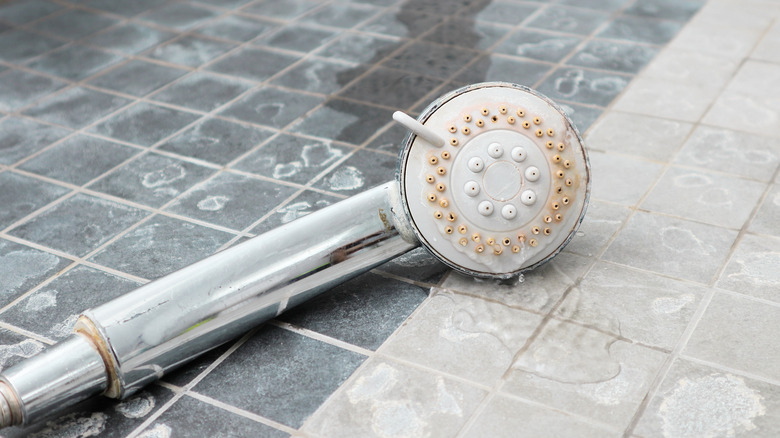 showerhead with limescale on floor